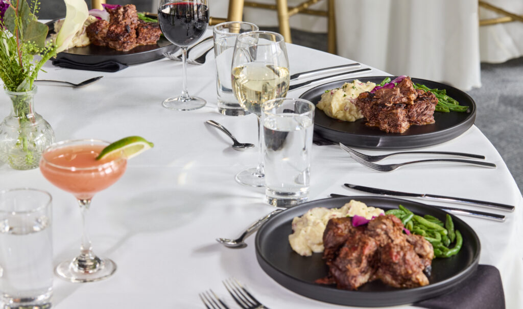 a table with plates of food and glasses of wine